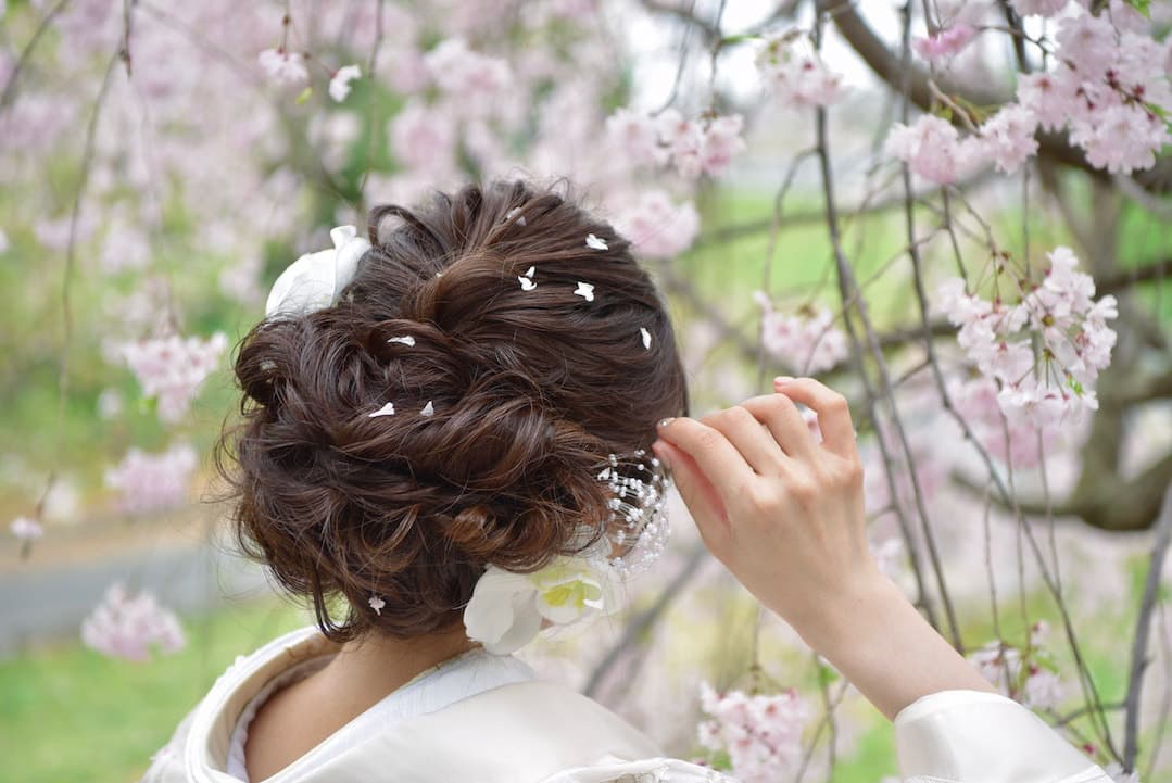 桜の花弁をつけた髪の結婚式の写真