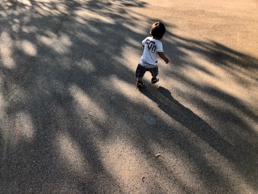 夕焼けの中走る男の子の写真