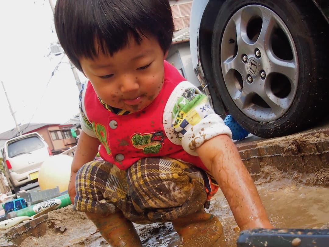 泥だらけの男の子の写真