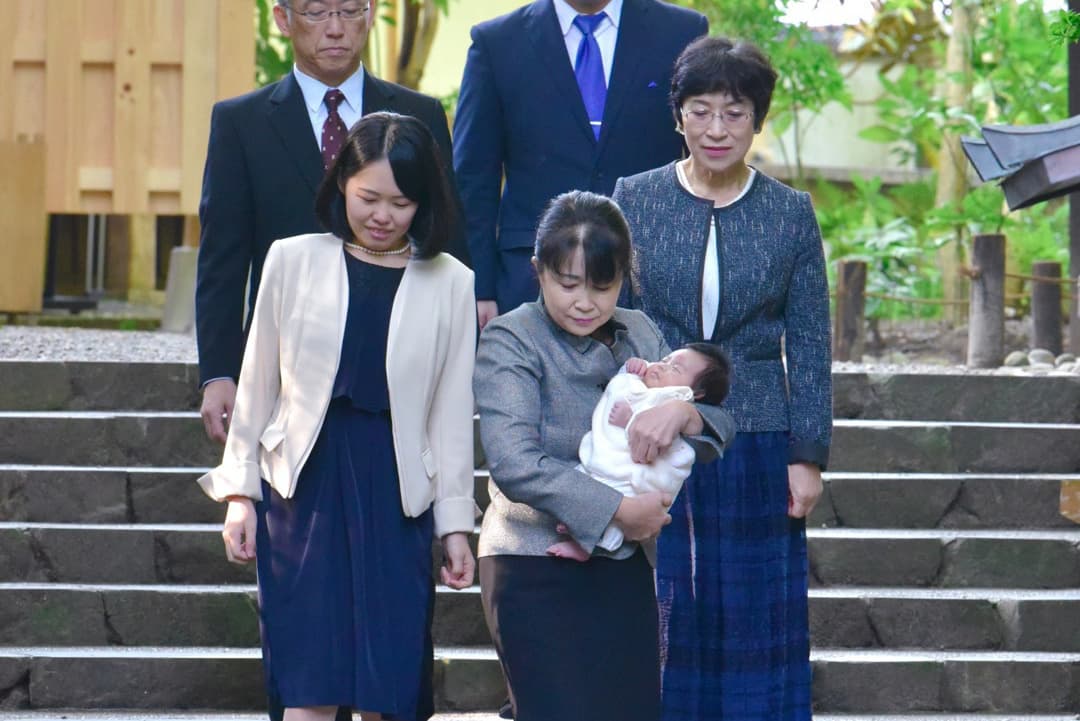 お宮参りで赤ちゃんを抱っこしている写真