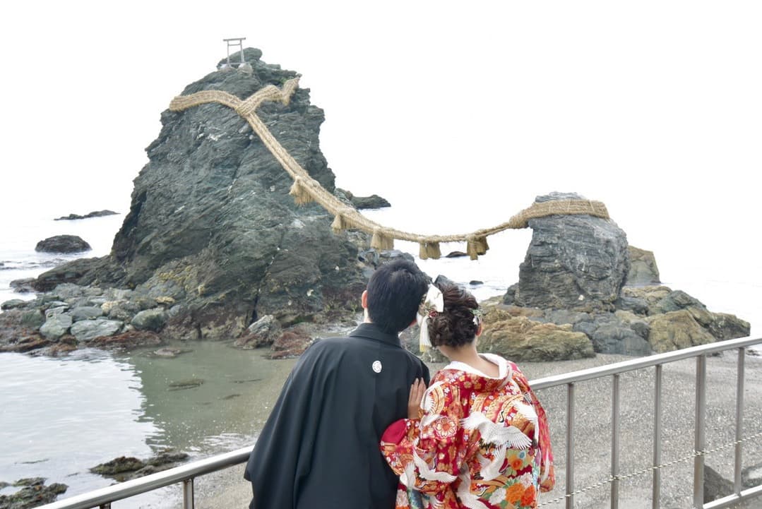 夫婦岩を見る新郎新婦の結婚写真