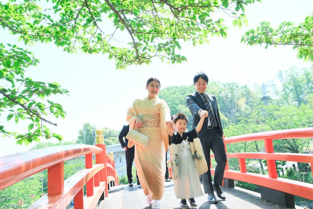 神社で七五三参りをする家族