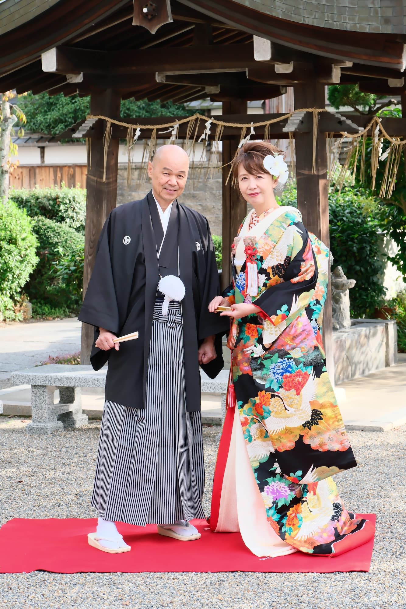 神社で記念写真を撮影している夫婦