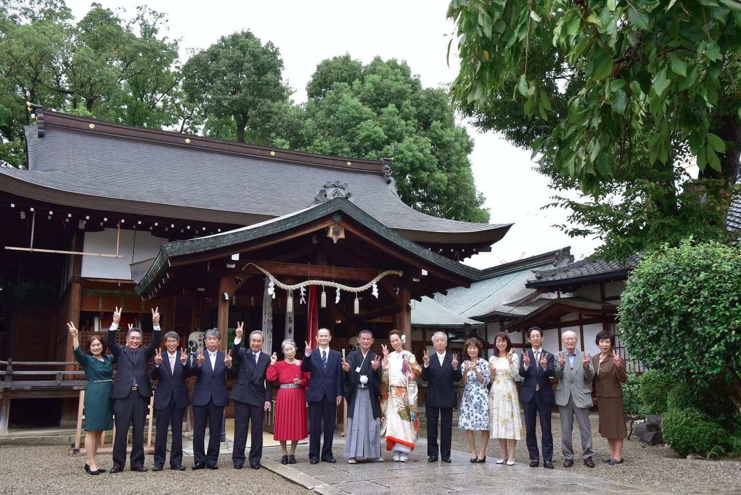 神社のの前で結婚記念写真を撮っている家族友人