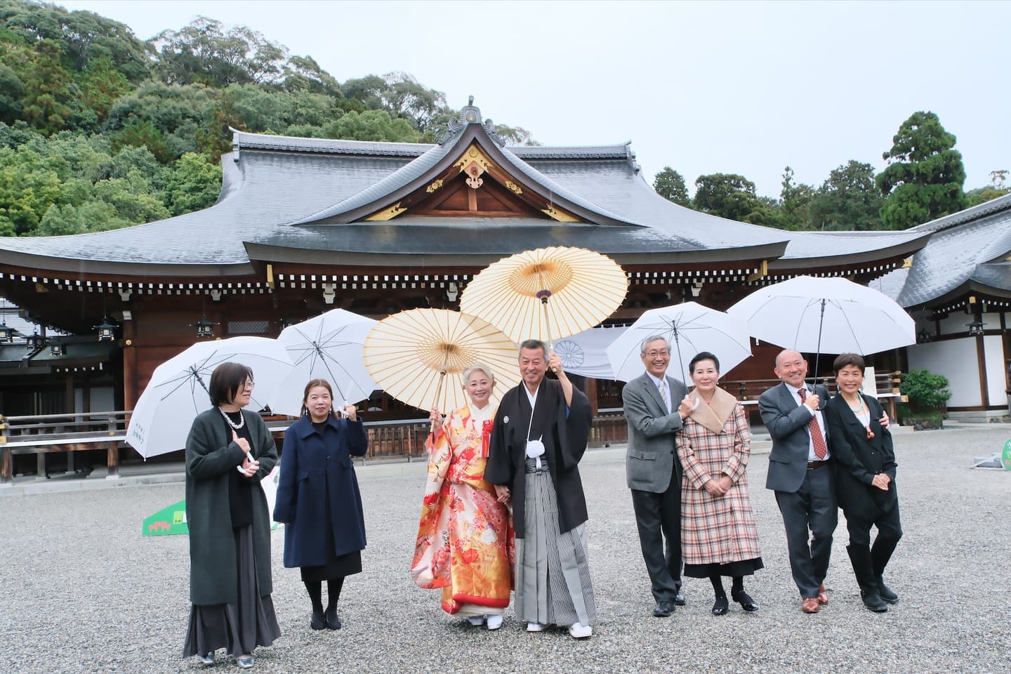 神社で家族友人と話す新郎新婦